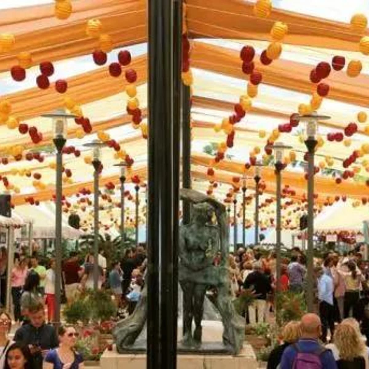 Ambiente de la Feria de Día Marbella 2026 en el Parque de la Alameda, con farolillos, barras, música, baile y público disfrutando en el centro.
