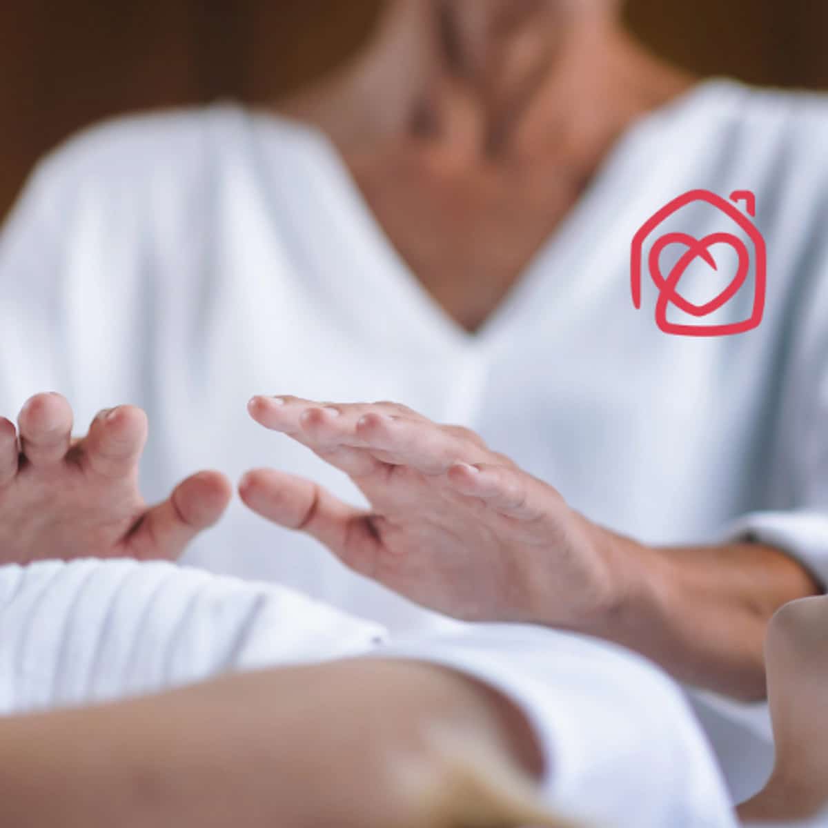 Sesión de reiki para adultos en Casa Ángeles Marbella, terapeuta aplicando terapia energética con manos sobre el cuerpo en ambiente relajante de bienestar y equilibrio emocional.
